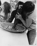 East Memorial Elementary School student crushing corn in a bowl by Dan Wooley