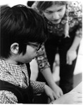 Beth Miner guiding an East Memorial Elementary School student in an activity by Dan Wooley