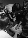 Children grinding grain with mano and metate