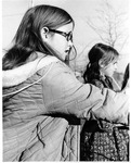 Two girls play a hoop and arrow game