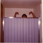 Person peering over shower door, ca. 1960s or 70s