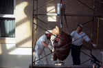University of Northern Colorado facilities workers carefully lower a Tlingit Bear Clan Totem from its mount in the University Center, October 20, 2003 by Kevin Moloney